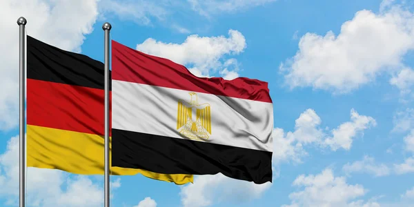 Bandera de Alemania y Egipto ondeando en el viento contra el cielo azul nublado blanco juntos. Concepto diplomático, relaciones internacionales . — Foto de Stock
