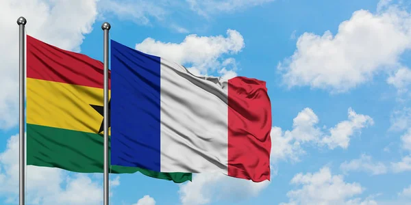 Bandera de Ghana y Francia ondeando en el viento contra el cielo azul nublado blanco juntos. Concepto diplomático, relaciones internacionales . — Foto de Stock