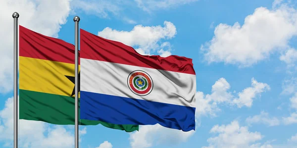 Bandera de Ghana y Paraguay ondeando en el viento contra el cielo azul nublado blanco juntos. Concepto diplomático, relaciones internacionales . — Foto de Stock