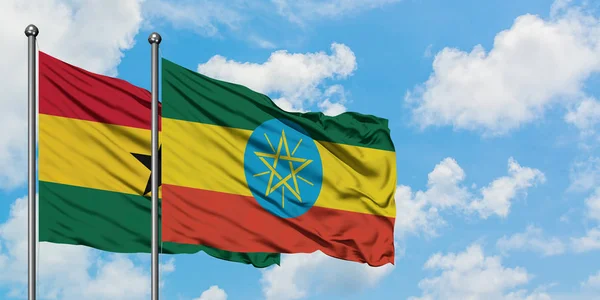 一緒に白い曇り青い空に対して風に振るガーナとエチオピアの旗。外交概念、国際関係. — ストック写真