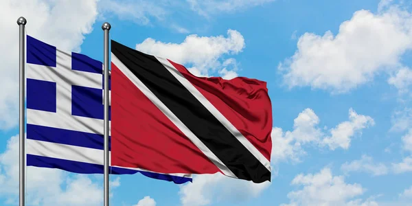 Grécia e Trinidad E Tobago bandeira acenando no vento contra branco céu azul nublado juntos. Conceito de diplomacia, relações internacionais . — Fotografia de Stock