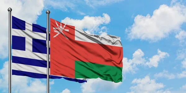 Greece and Oman flag waving in the wind against white cloudy blue sky together. Diplomacy concept, international relations. — Stock Photo, Image