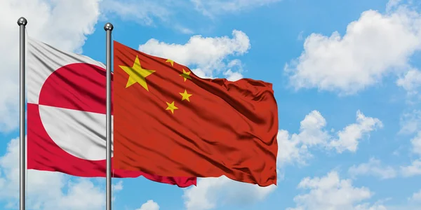 Groenlandia e Cina bandiera sventolando nel vento contro bianco cielo blu nuvoloso insieme. Concetto di diplomazia, relazioni internazionali . — Foto Stock