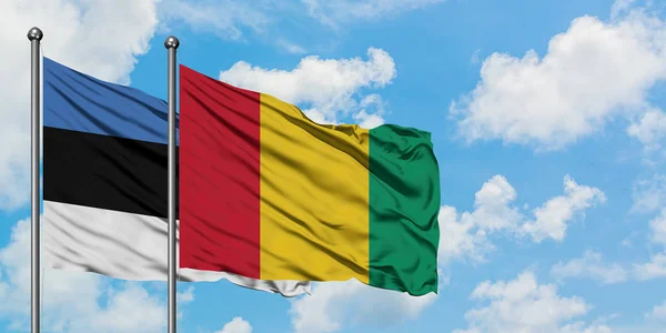 爱沙尼亚和几内亚国旗在风中飘扬，白云蓝天相聚。外交概念、国际关系. — 图库照片