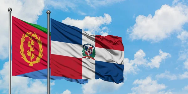 Bandera de Eritrea y República Dominicana ondeando en el viento contra el cielo azul nublado blanco juntos. Concepto diplomático, relaciones internacionales . — Foto de Stock