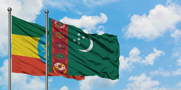 Etiopie a Turkmenistán vlají ve větru proti bíle zatažené modré obloze. Diplomacie, mezinárodní vztahy. — Stock fotografie