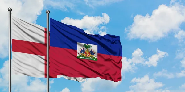 İngiltere ve Haiti bayrağı birlikte beyaz bulutlu mavi gökyüzüne karşı rüzgarda sallayarak. Diplomasi kavramı, uluslararası ilişkiler. — Stok fotoğraf