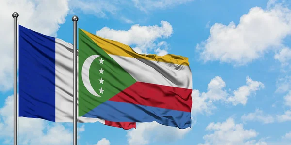 Bandera de Francia y Comoras ondeando en el viento contra el cielo azul nublado blanco juntos. Concepto diplomático, relaciones internacionales . — Foto de Stock