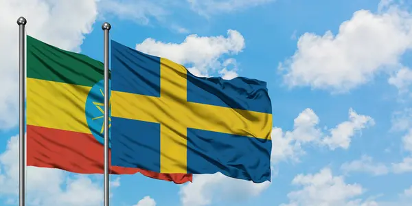 埃塞俄比亚和瑞典国旗在风中飘扬，与白云蓝天相一起。外交概念、国际关系. — 图库照片