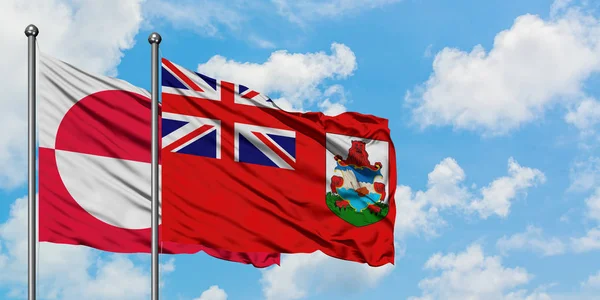 Bandera de Groenlandia y Bermudas ondeando en el viento contra el cielo azul nublado blanco juntos. Concepto diplomático, relaciones internacionales . —  Fotos de Stock