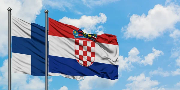 Finsko a chorvatská vlajka mávali ve větru proti bíle zatažené modré obloze. Diplomacie, mezinárodní vztahy. — Stock fotografie