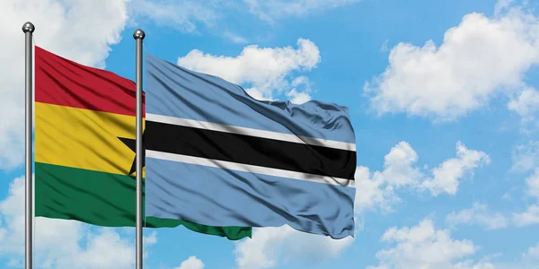 Ghana e Botswana sventolano nel vento contro il bianco cielo blu nuvoloso insieme. Concetto di diplomazia, relazioni internazionali . — Foto Stock