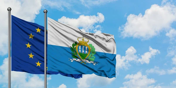 Європейський Союз і Сан-Марино прапора розмахуючи в вітру проти білого хмарного синього неба разом. Концепція дипломатії, міжнародні відносини. — стокове фото