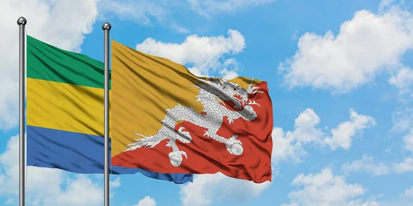 加蓬和不丹国旗在风中飘扬，与白云蓝天相一起。外交概念、国际关系. — 图库照片