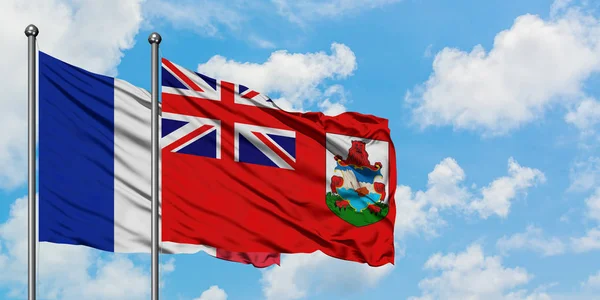 Bandera de Francia y Bermudas ondeando en el viento contra el cielo azul nublado blanco juntos. Concepto diplomático, relaciones internacionales . — Foto de Stock