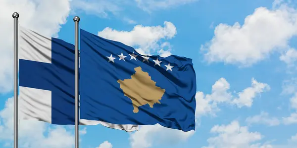 Фінляндія і Косово прапор розмахував вітром проти білого хмарного синього неба разом. Концепція дипломатії, міжнародні відносини. — стокове фото