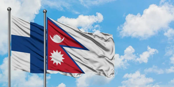 Finland and Nepal flag waving in the wind against white cloudy blue sky together. Diplomacy concept, international relations. — Stock Photo, Image