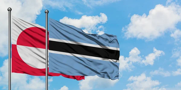 Groenlandia e Botswana sventolano insieme contro il bianco cielo blu nuvoloso. Concetto di diplomazia, relazioni internazionali . — Foto Stock