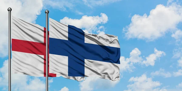 Англія і Фінляндія прапор розмахуючи в вітру проти білого хмарного синього неба разом. Концепція дипломатії, міжнародні відносини. — стокове фото