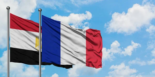 Bandera de Egipto y Francia ondeando en el viento contra el cielo azul nublado blanco juntos. Concepto diplomático, relaciones internacionales . — Foto de Stock