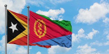 Doğu Timor ve Eritre bayrağı birlikte beyaz bulutlu mavi gökyüzüne karşı rüzgarda sallayarak. Diplomasi kavramı, uluslararası ilişkiler.