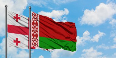 Gürcistan ve Beyaz Rusya bayrağı birlikte beyaz bulutlu mavi gökyüzüne karşı rüzgarda sallayarak. Diplomasi kavramı, uluslararası ilişkiler.