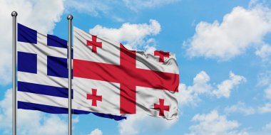 Yunanistan ve Gürcistan bayrağı birlikte beyaz bulutlu mavi gökyüzüne karşı rüzgarsal sallayarak. Diplomasi kavramı, uluslararası ilişkiler.