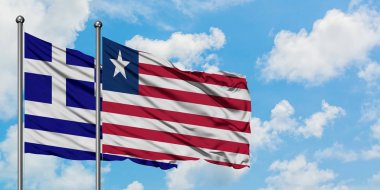 Yunanistan ve Liberya bayrağı birlikte beyaz bulutlu mavi gökyüzüne karşı rüzgarda sallayarak. Diplomasi kavramı, uluslararası ilişkiler.