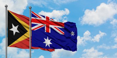 Doğu Timor ve Heard Adası ve Mcdonald Adaları bayrağı birlikte beyaz bulutlu mavi gökyüzüne karşı rüzgarda sallayarak. Diplomasi kavramı, uluslararası ilişkiler.