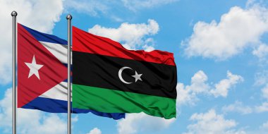 Küba ve Libya bayrağı birlikte beyaz bulutlu mavi gökyüzüne karşı rüzgarsal sallayarak. Diplomasi kavramı, uluslararası ilişkiler.