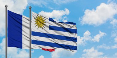 Fransa ve Uruguay bayrağı birlikte beyaz bulutlu mavi gökyüzüne karşı rüzgarsal sallayarak. Diplomasi kavramı, uluslararası ilişkiler.