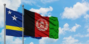 Curacao ve Afganistan bayrağı birlikte beyaz bulutlu mavi gökyüzüne karşı rüzgarda sallayarak. Diplomasi kavramı, uluslararası ilişkiler.