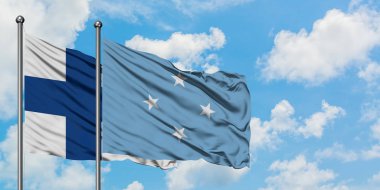 Finlandiya ve Mikronezya bayrağı birlikte beyaz bulutlu mavi gökyüzüne karşı rüzgarsal sallayarak. Diplomasi kavramı, uluslararası ilişkiler.