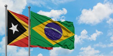 Doğu Timor ve Brezilya bayrağı birlikte beyaz bulutlu mavi gökyüzüne karşı rüzgarda sallayarak. Diplomasi kavramı, uluslararası ilişkiler.