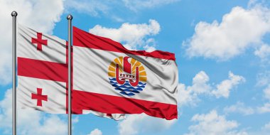 Gürcistan ve Fransız Polinezyası bayrağı birlikte beyaz bulutlu mavi gökyüzüne karşı rüzgarda sallayarak. Diplomasi kavramı, uluslararası ilişkiler.