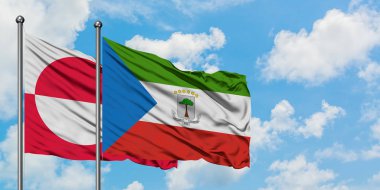 Grönland ve Ekvator Ginesi bayrağı birlikte beyaz bulutlu mavi gökyüzüne karşı rüzgarda sallayarak. Diplomasi kavramı, uluslararası ilişkiler.