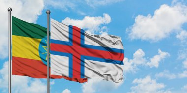 Etiyopya ve Faroe Adaları bayrağı birlikte beyaz bulutlu mavi gökyüzüne karşı rüzgarda sallayarak. Diplomasi kavramı, uluslararası ilişkiler.