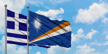 Yunanistan ve Marshall Adaları bayrağı birlikte beyaz bulutlu mavi gökyüzüne karşı rüzgarda sallayarak. Diplomasi kavramı, uluslararası ilişkiler.