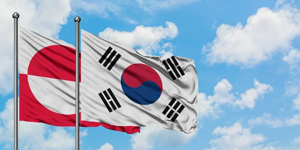 Groenland en Zuid-Korea vlag zwaaien in de wind tegen witte bewolkte blauwe hemel samen. Diplomatie concept, internationale betrekkingen. — Stockfoto