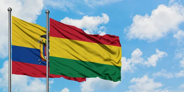 Η σημαία του Ισημερινού και της Βολιβία κουνώντας τον άνεμο ενάντια στον λευκό συννεφιασμένο γαλάζιο ουρανό μαζί. Φιλοσοφία της διπλωματίας, διεθνείς σχέσεις. — Φωτογραφία Αρχείου