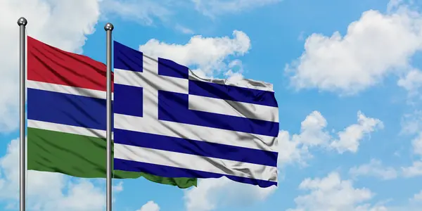 Gambia e la Grecia bandiera sventolando nel vento contro bianco cielo blu nuvoloso insieme. Concetto di diplomazia, relazioni internazionali . — Foto Stock