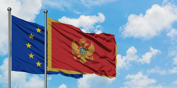 European Union and Montenegro flag waving in the wind against white cloudy blue sky together. Diplomacy concept, international relations. — Stock Photo, Image