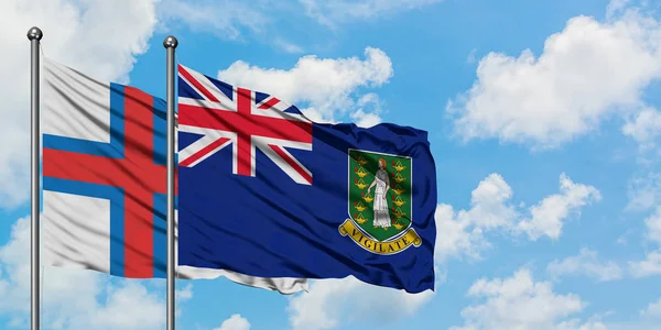 Bandera de las Islas Feroe y las Islas Vírgenes Británicas ondeando en el viento contra el cielo azul nublado blanco juntos. Concepto diplomático, relaciones internacionales . —  Fotos de Stock