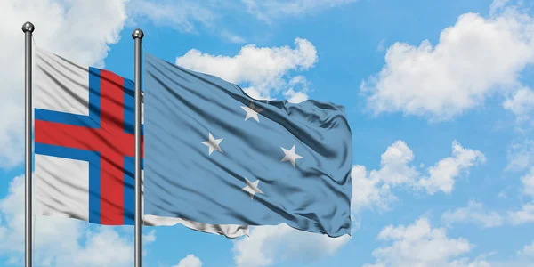 Фарерські острови і Мікронезія прапор розмахуючи на вітрі від білого хмарного синього неба разом. Концепція дипломатії, міжнародні відносини. — стокове фото