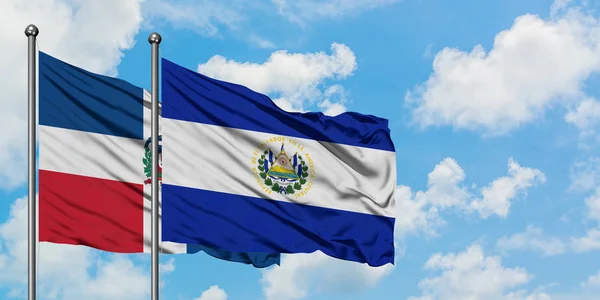 Dominikanische Republik und El Salvador Flagge wehen gemeinsam im Wind vor weißem wolkenblauem Himmel. Diplomatie-Konzept, internationale Beziehungen. — Stockfoto
