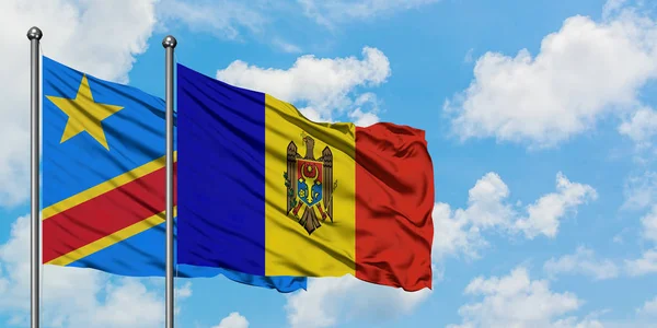 Bandera del Congo y Moldavia ondeando en el viento contra el cielo azul nublado blanco juntos. Concepto diplomático, relaciones internacionales . — Foto de Stock