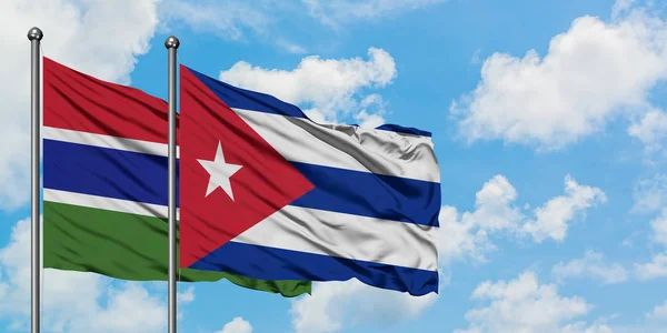 Gambie et Cuba drapeau agitant dans le vent contre ciel bleu nuageux blanc ensemble. Concept de diplomatie, relations internationales . — Photo
