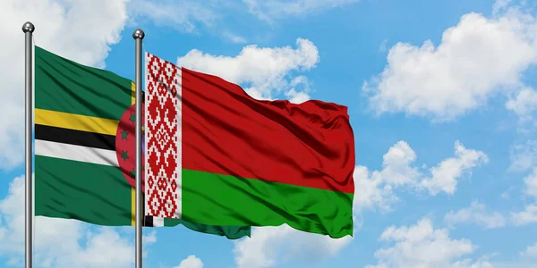 Bandera de Dominica y Bielorrusia ondeando en el viento contra el cielo azul nublado blanco juntos. Concepto diplomático, relaciones internacionales . — Foto de Stock