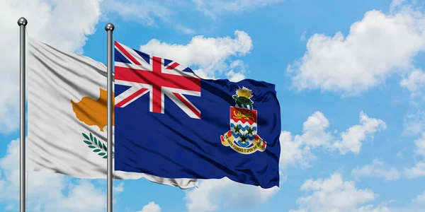 Bandera de Chipre y las Islas Caimán ondeando en el viento contra el cielo azul nublado blanco juntos. Concepto diplomático, relaciones internacionales . — Foto de Stock