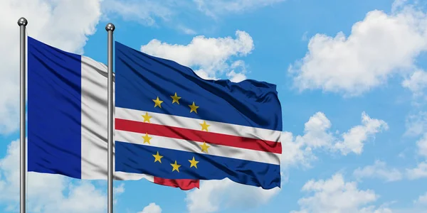 Bandera de Francia y Cabo Verde ondeando en el viento contra el cielo azul nublado blanco juntos. Concepto diplomático, relaciones internacionales . — Foto de Stock